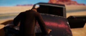 El Paso, Elsewhere – Figur vor einem Auto in der Wüste